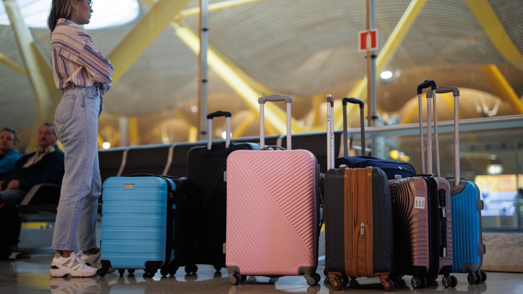 Una mujer espera con las maletas en el aeropuerto.