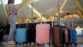 Una mujer espera con las maletas en el aeropuerto.