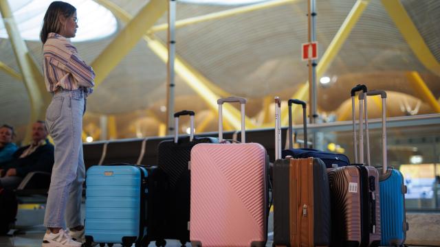 Una mujer espera con las maletas en el aeropuerto.