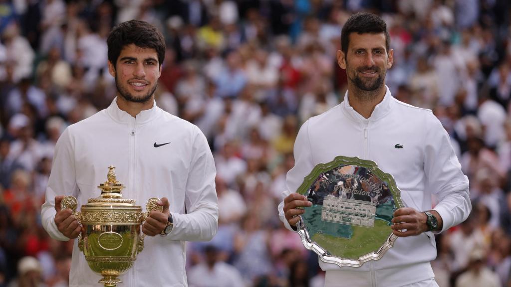 Alcaraz posa con el trofeo de ganador de Wimbledon junto a Novak Djokovic.
