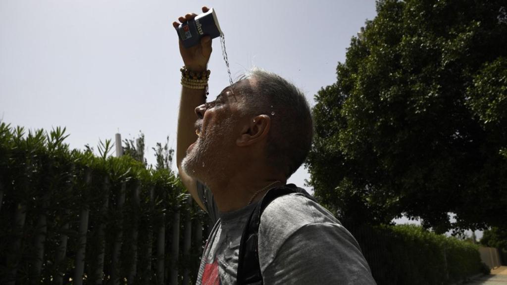Una persona se refresca en una calle en Roquetas de Mar (Almería).