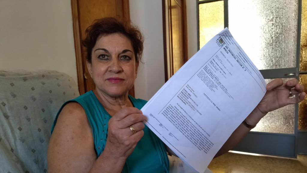 Dolores, en su casa de El Palmar, este martes, mostrando la sentencia de la Audiencia Provincial de Murcia que le ha retirado la pensión compensatoria que le pagaba su exmarido.