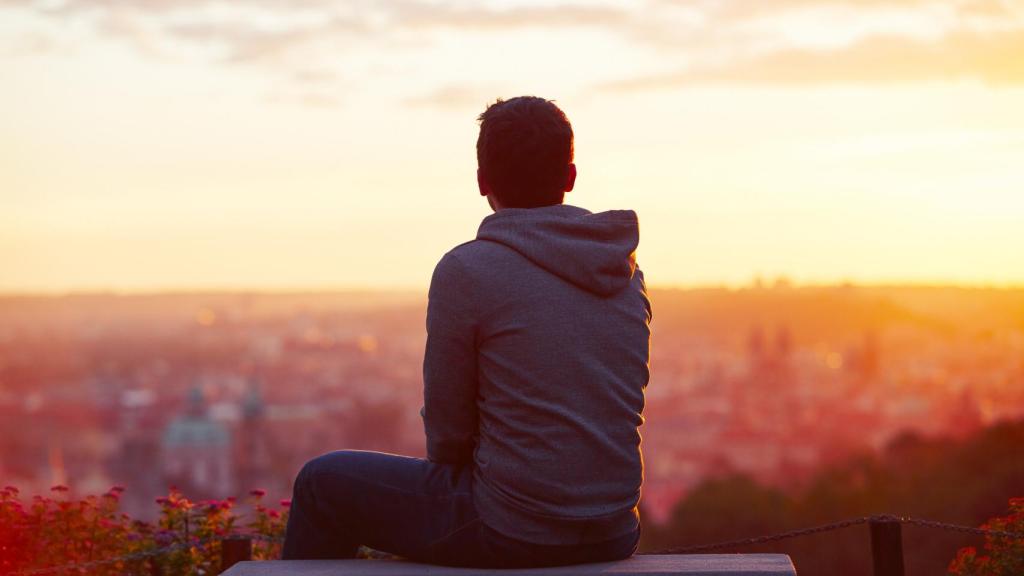Persona esperando en un banco al atardecer. Foto: iStock.