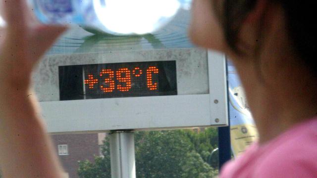 Un hombre pasea por una calle de Valladolid delante de un termóemtro que marca 39 grados.