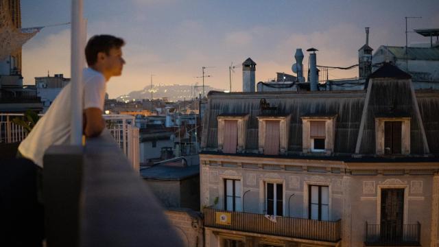 Un hombre mirando un edificio de pisos.