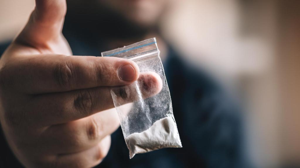 Una persona simula la entrega de cocaína a otra persona, en una imagen de archivo.