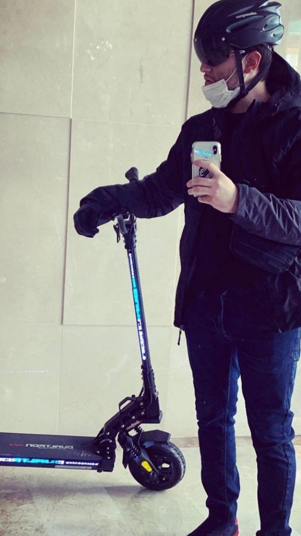 Alejandro, con casco, posando con el patinete eléctrico que se compró ante de sufrir el accidente en Granada.