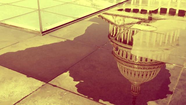 La cúpula del Capitolio de Estados Unidos se refleja en un charco de agua en Washington.