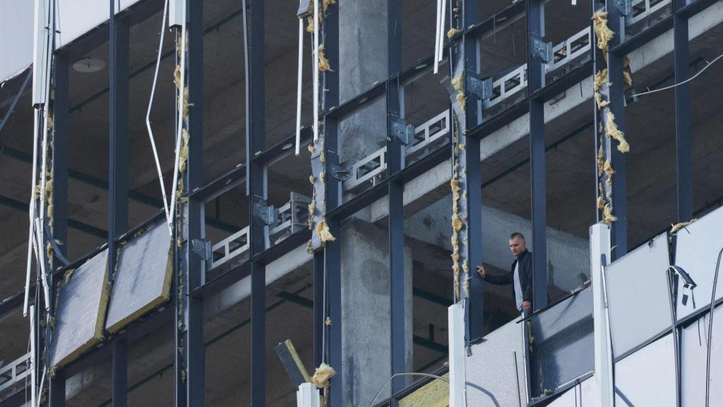 Una persona de seguridad analiza los daños provocados por un dron contra un edificio en el centro de Moscú.