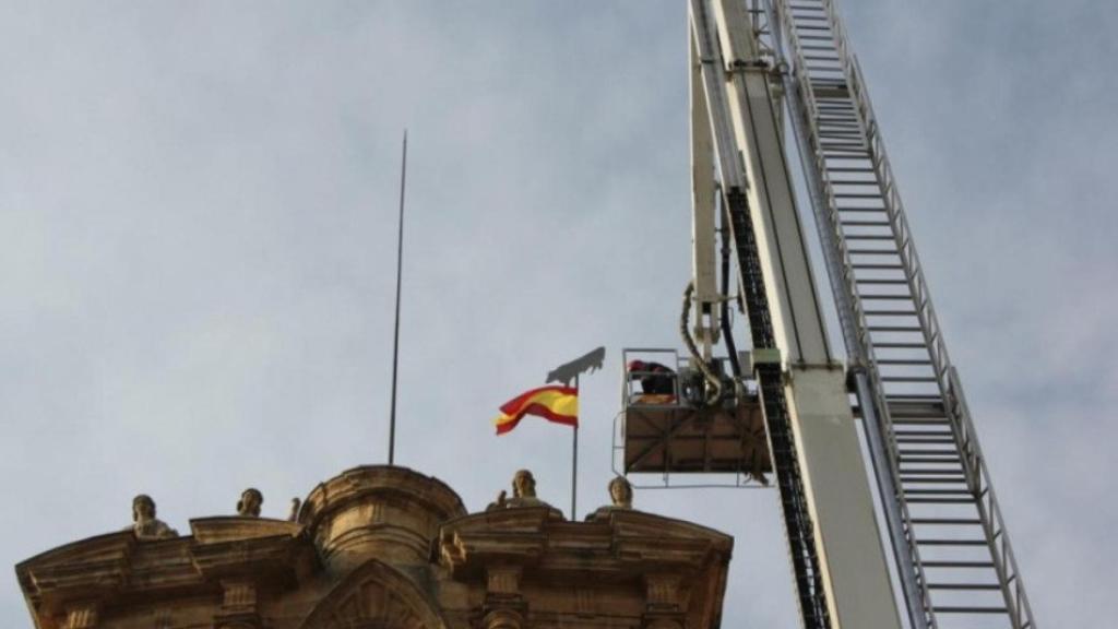 Colocación de La Mariseca en la espadaña del Ayuntamiento por los bomberos