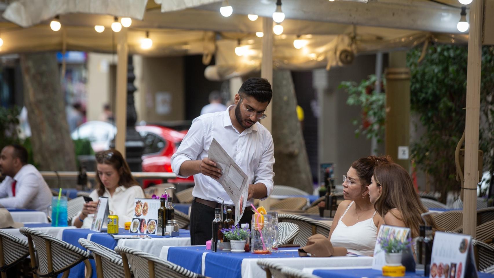 Un camarero atiende a una mesa en las Ramblas.