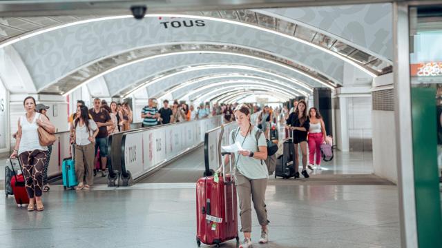 Varias personas con maletas en las instalaciones de la estación Almudena Grandes-Atocha Cercanías.