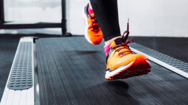 Imagen de archivo de una mujer corriendo en una cinta de gimnasio