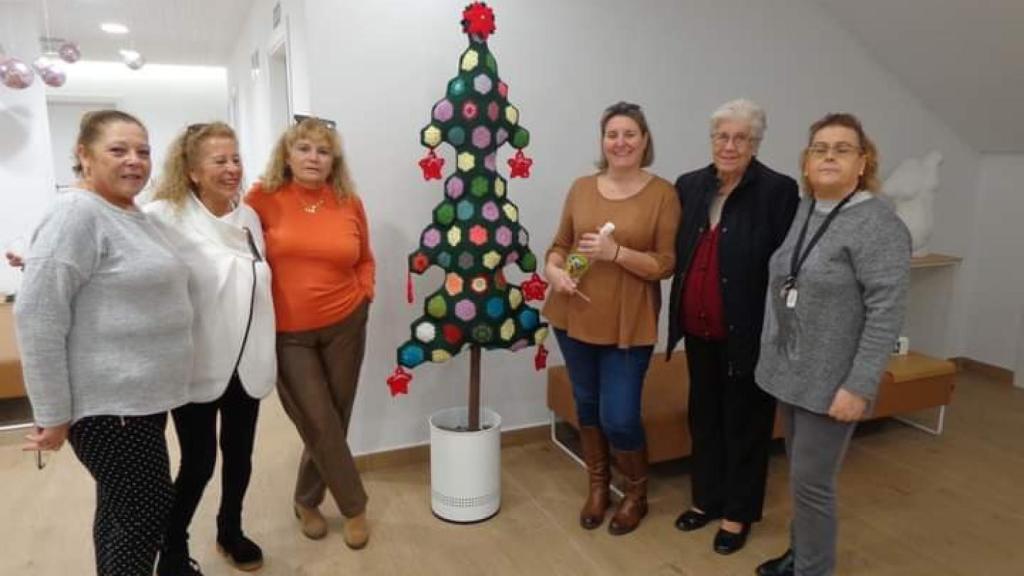 Algunas chicas posan con un árbol.