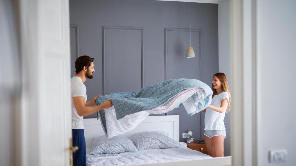 Una pareja haciendo la cama.