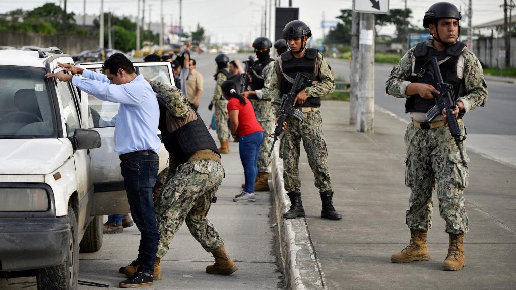 Un agente cachea a un hombre fuera de la Penitenciaria del Litoral tras un motín, el 14 de abril.
