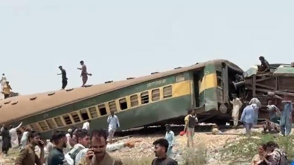 Una multitud acude al lugar del accidente para ayudar a los pasajeros atrapados en el tren.