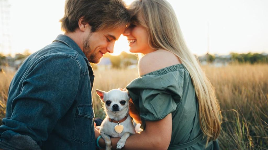 Una pareja junto a su perro.