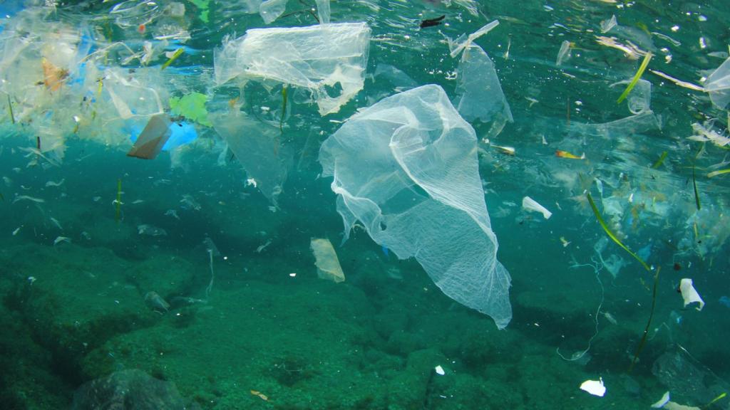 Imagen de archivo de basura plástica hundiéndose en el mar.