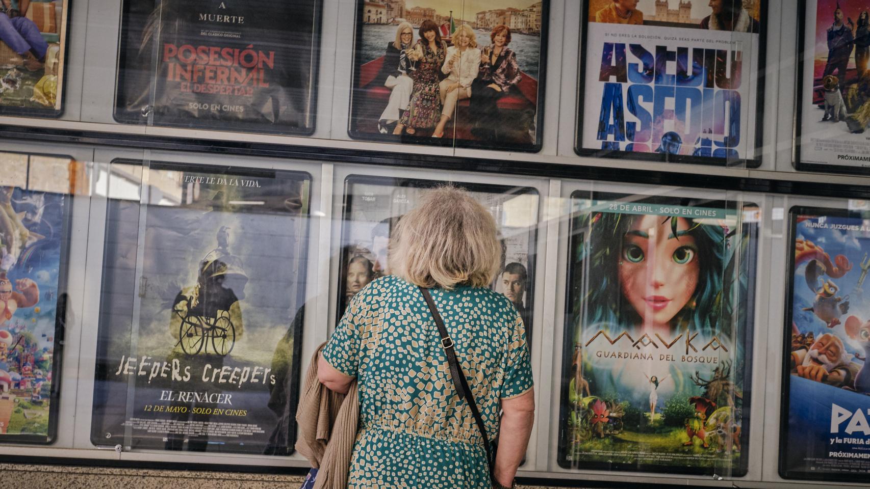 Una señora frente a la cartelera de los Cines Galicine Ponte Vella, en Orense (Galicia).