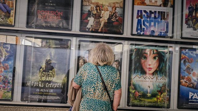 Una señora frente a la cartelera de los Cines Galicine Ponte Vella, en Orense (Galicia).