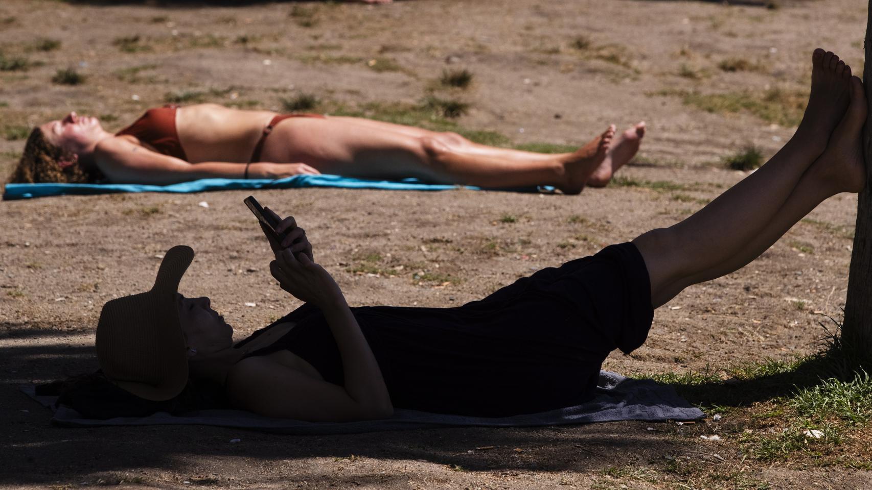Un hombre se refugia a la sombra.