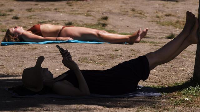 Un hombre se refugia a la sombra.