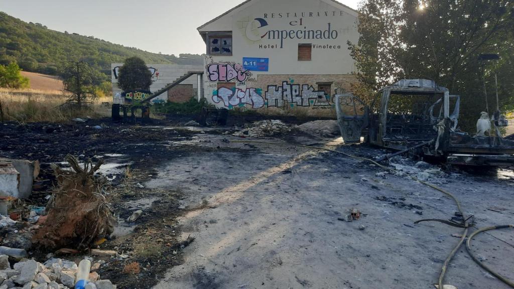 Los bomberos extinguen el fuego en el camión junto al restaurante El Empecinado