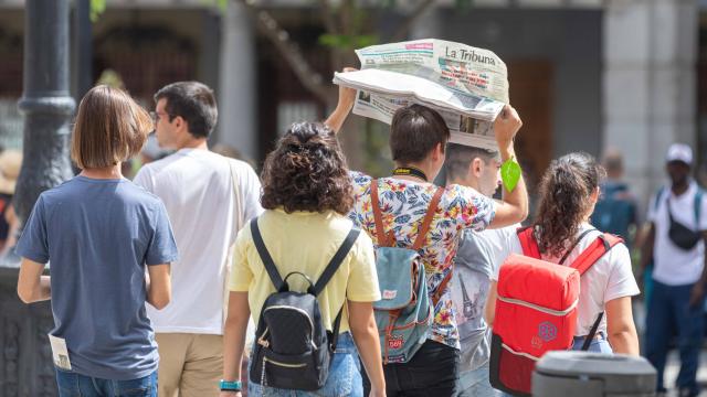 Un turista se protege del sol con un periódico en la plaza de Zocodover (Toledo).