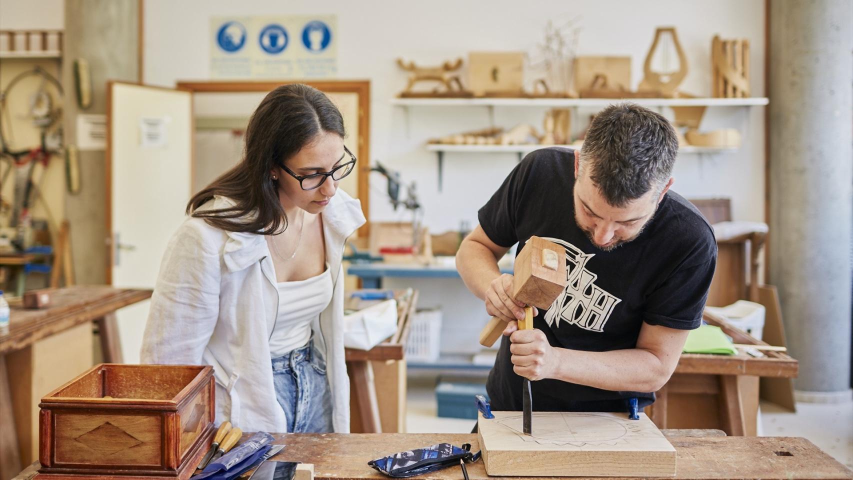 Dos personas trabajan con maderas, en Orense.