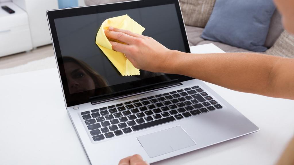 Imagen de archivo de una mujer limpiando la pantalla de su ordenador.