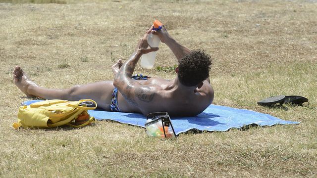 Un hombre toma el sol en la zona piscinas de Oira, en Ourense.