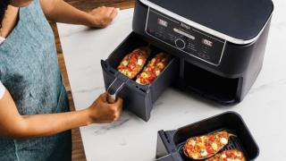 Una niña cocina con la freidora de aire.