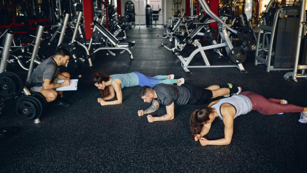 Grupo de deportistas realizando ejercicios de plancha abdominal.