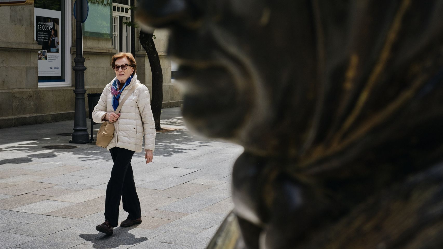 Una señora pasea por una de las calles de la ciudad.