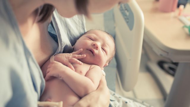 Una madre abraza a su hijo recién nacido en el hospital.