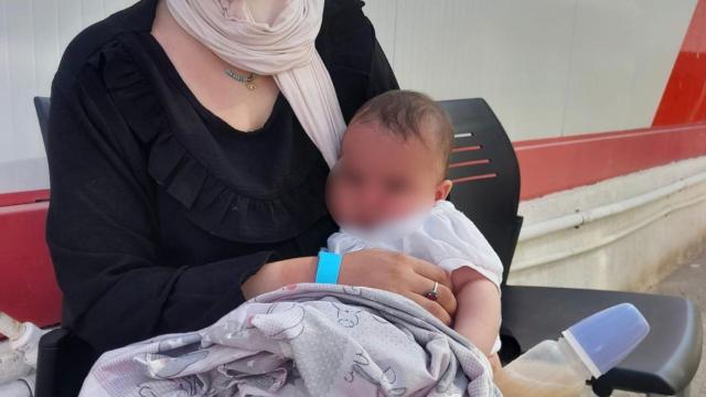 Una madre sosteniendo a su hijo tras su llegada en patera a Alicante.