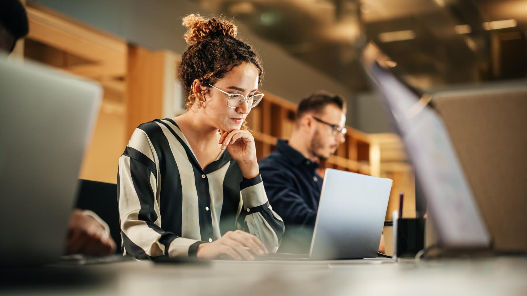 Una mujer joven utilizando un ordenador en la oficina, en una imagen de archivo.