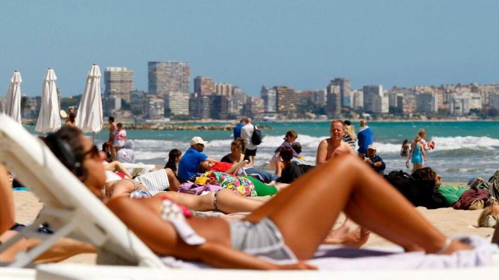 Una mujer tomando el sol en la playa.