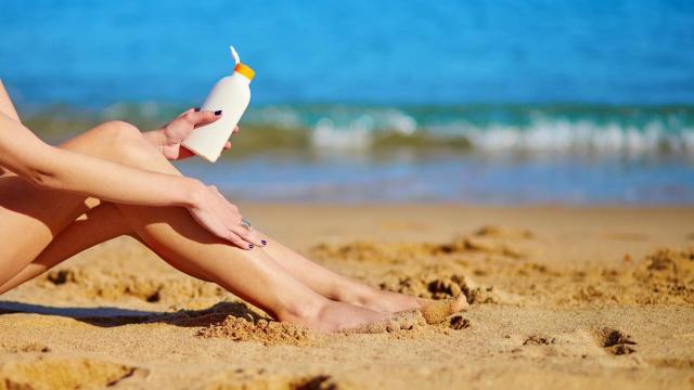 Una mujer echándose crema.