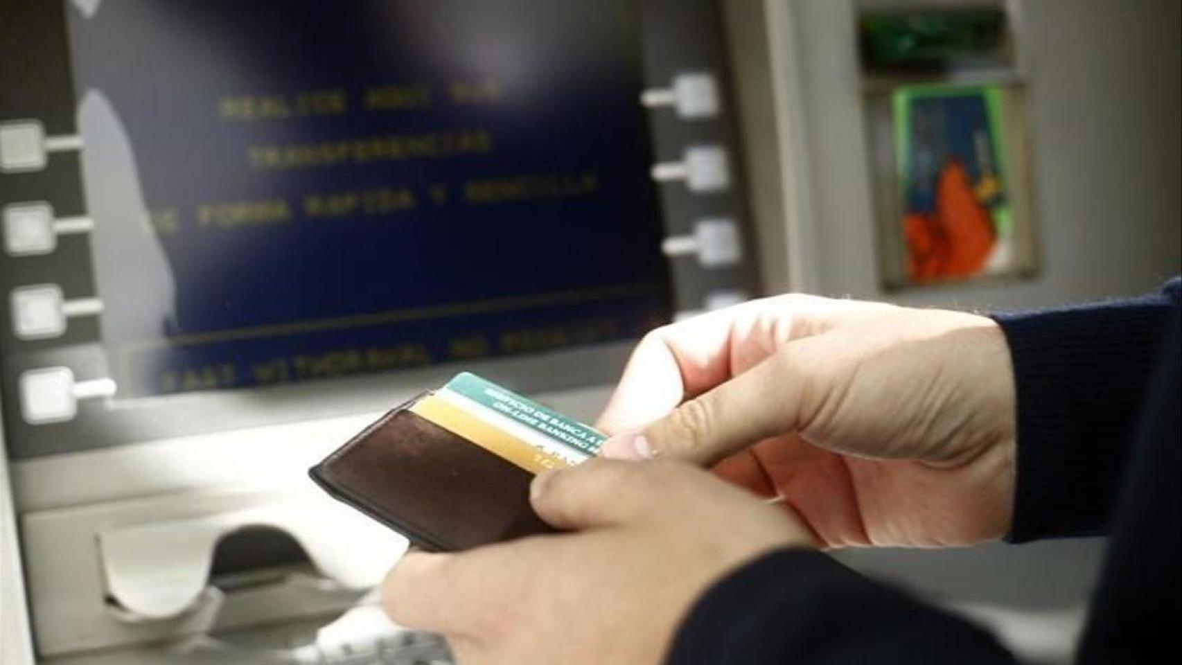 Imagen de archivo de una persona sacando dinero de un cajero automático.