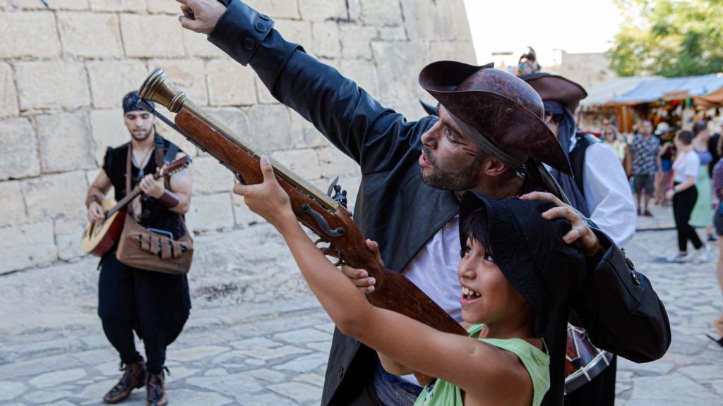 Un actor del evento, con un niño del público asistente.
