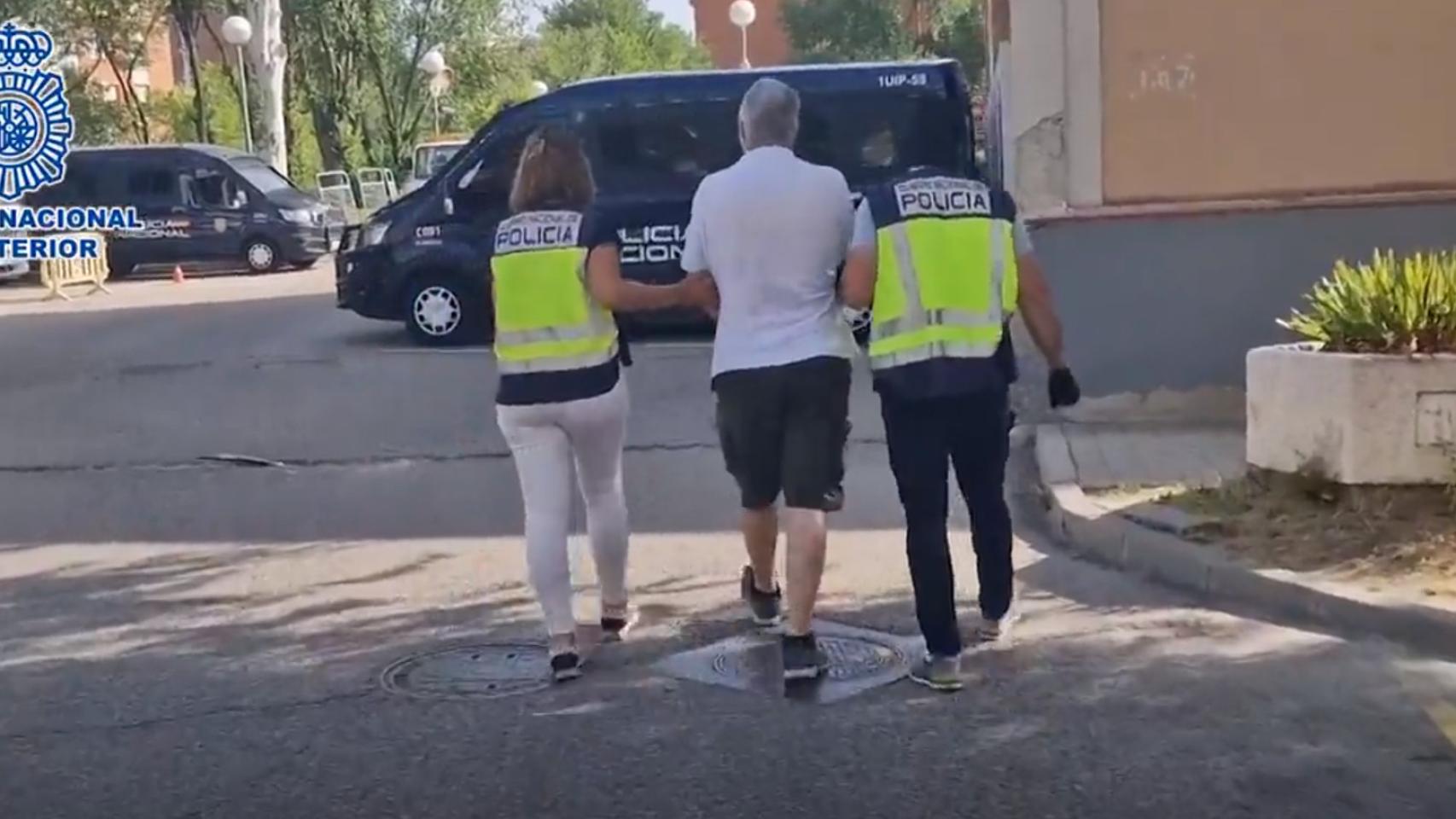 Dos policías nacionales detienen a un delincuente.