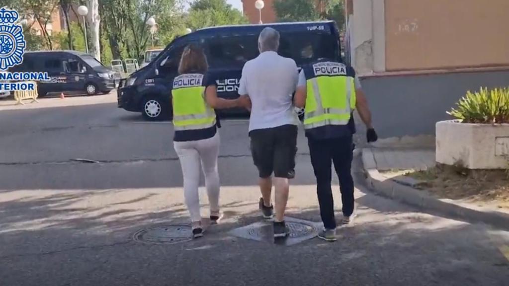 Dos policías nacionales detienen a un delincuente.