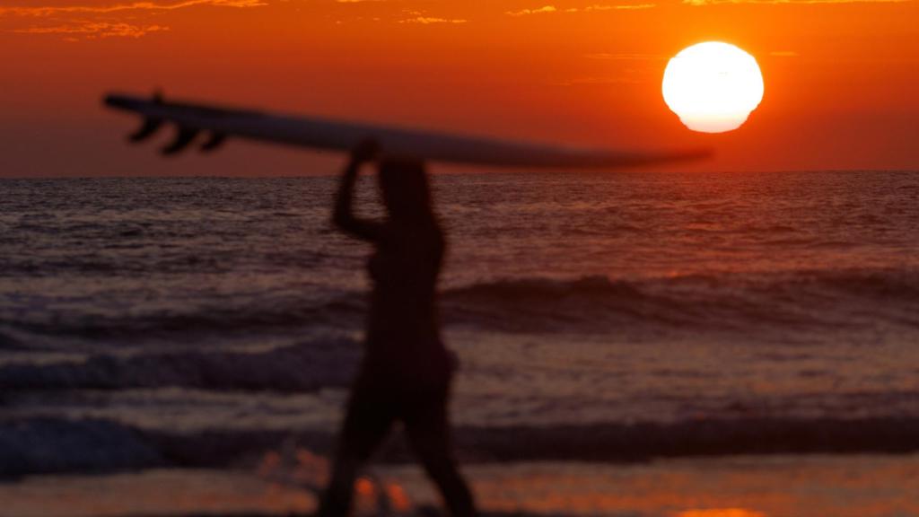 Una surfista en la playa en Cardiff State Beach en Encinitas, California (EEUU).