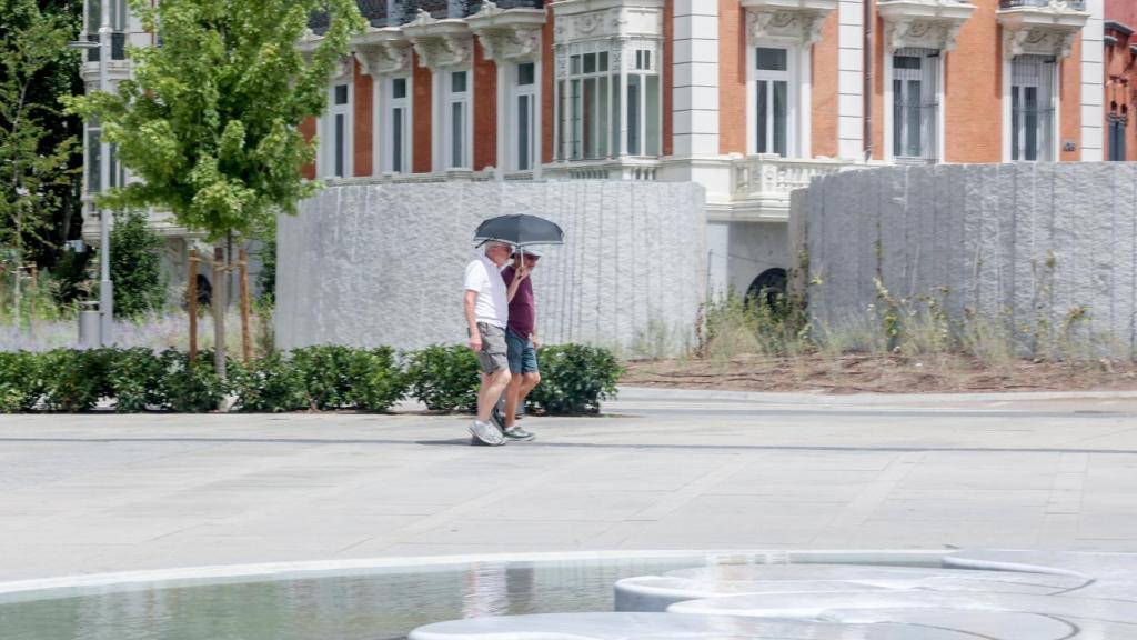 Una pareja pasea por Madrid durante el mes de agosto.