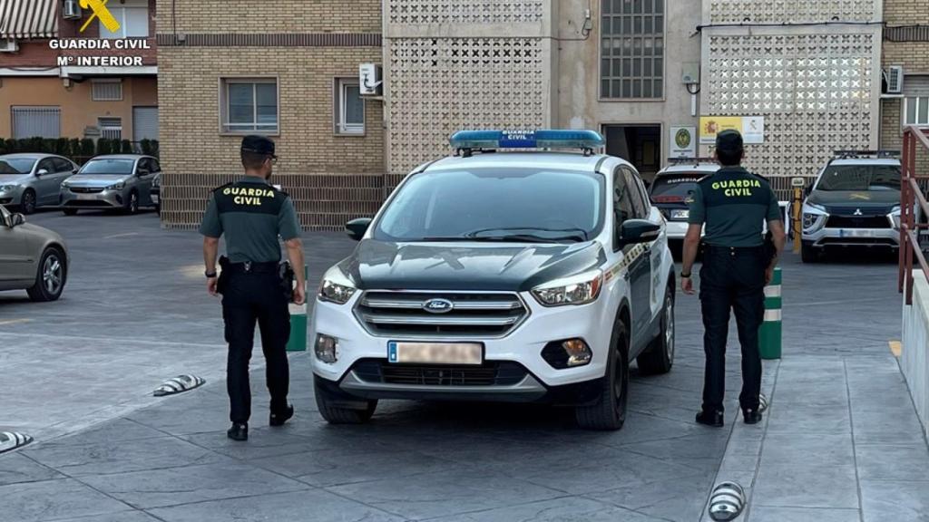 Dos agentes de la Guardia Civil frente a un coche patrulla, en una operación anterior.