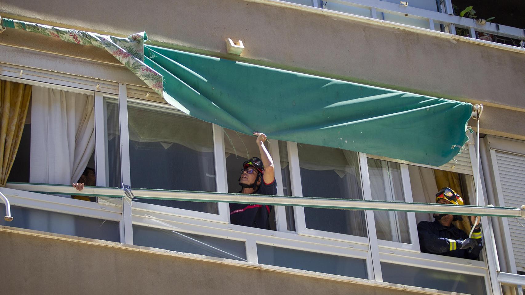 Los bomberos de Málaga comprobando un toldo por el viento.