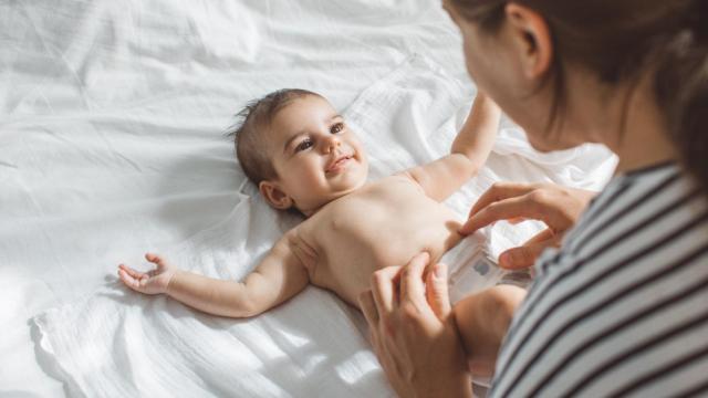 Imagen de archivo de una mujer cambiándole el pañal a un bebé.