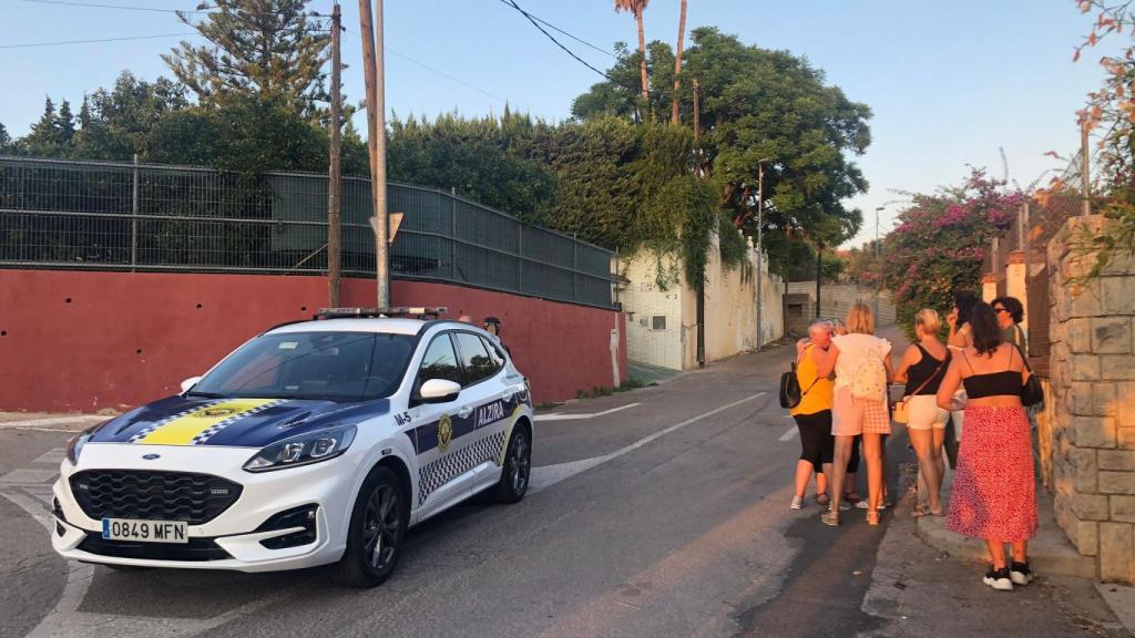 Familiares y amigos de Raquel, junto al coche policial que impedía el acceso a la vivienda del asesinato. EE